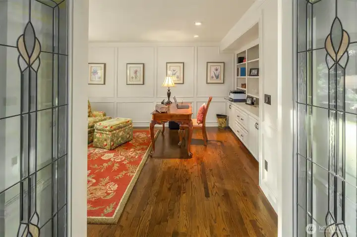 Leaded glass french doors lead into the den/office. More built in cabinets and bookshelves.