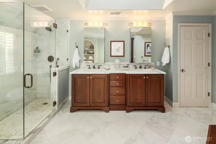 Primary bathroom with custom cabinetry, Robern medicine chests, skylight and marble counters, floors and shower. Floors are heated. Not pictured on the wall to the right is a built in furniture grade floor to ceiling cabinet for extra storage.