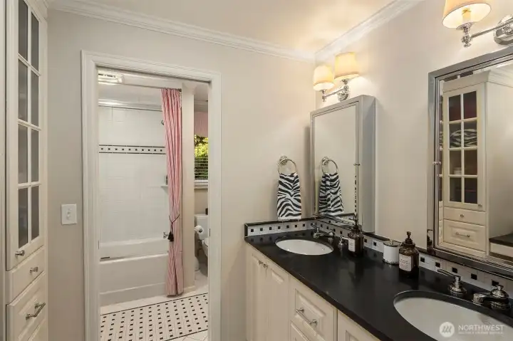 Hall bathroom with Restoration Hardware medicine chests, light fixtures, and faucets. Across from the sinks is a wall of floor to ceiling custom cabinetry and a makeup vanity. Heated floors too.
