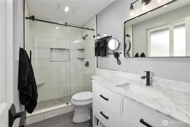 Primary Ensuite Bathroom BRAND NEW!!!!! Gorgeous remodeled and updated bathroom, new lighting, quartz vanity, tile floors, tile shower w/bench, shampoo niche and shelves plus new plumbing fixtures!