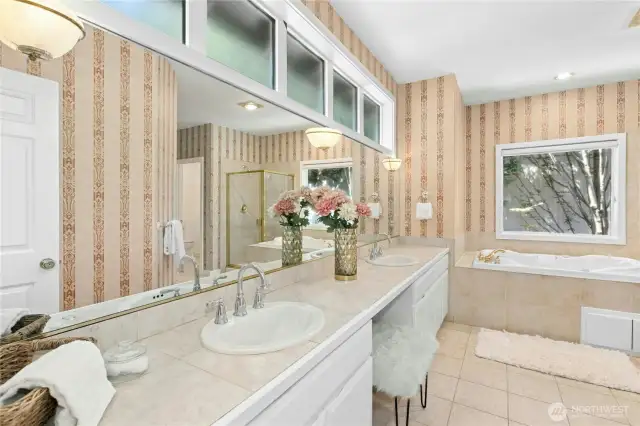 Ample cupboard space and double sinks with natural light above make primary bath luxurious.
