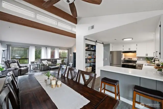 The natural light pours in through high transom windows, creating an airy, open feel that perfectly complements the cozy fireplace centerpiece.