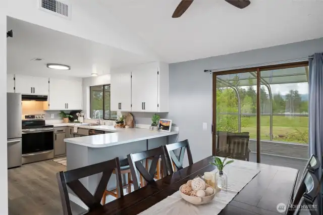 These elegant ceilings create a seamless flow into the adjoining dining room and sunroom, where panoramic windows frame the lush green landscape and Mountain views beyond.