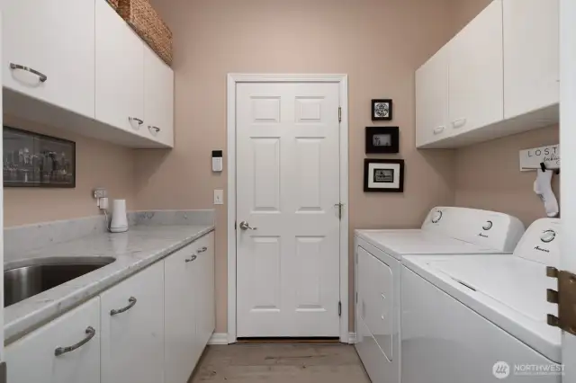 SPACIOUS AND FUNCTIONAL LAUNDRY ROOM - DOOR LEADS TO ENCLOSED UTILITY ROOM THEN 2 CAR GARAGE