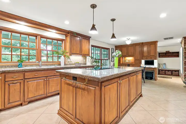 This kitchen is a true showstopper with an abundance of rich wood cabinetry, offering incredible storage and timeless style. The expansive windows with beautiful wood trim frame the outdoors perfectly, bringing in natural light and adding warmth to the space.