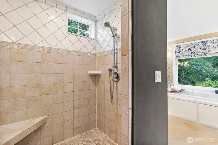 Step into the spacious walk-in shower with a seated area, beautifully finished with elegant tilework and designed to deliver a refreshing, spa-like experience in the comfort of home.