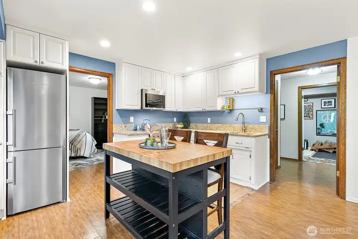 A cozy eat-in space flows seamlessly to the outdoors through a charming wood door, making it easy to enjoy meals inside or step out to the patio for lakefront living.