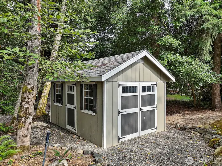 A charming storage shed, newly added in 2022, provides plenty of room for tools, lawn equipment, or hobbies, all while blending seamlessly into the natural landscape.