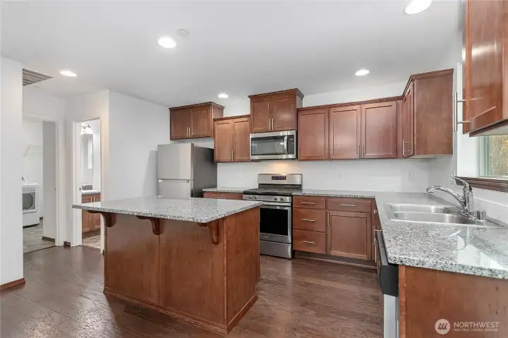 The hallway to the left leads to the utility room, 1/2 bathroom, and garage.
