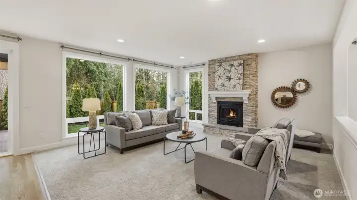 Wall of windows and statement fireplace highlight the welcoming great room.
