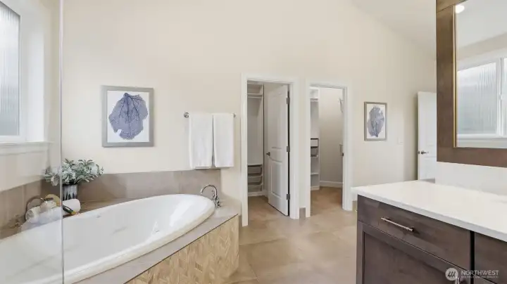 Spacious soaking tub and custom his and her closets