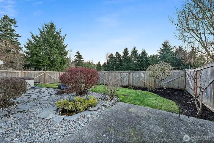 Well maintained and manicured backyard backs up to greenspace