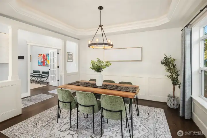 Dining room features a tray ceiling with integrated cove lighting