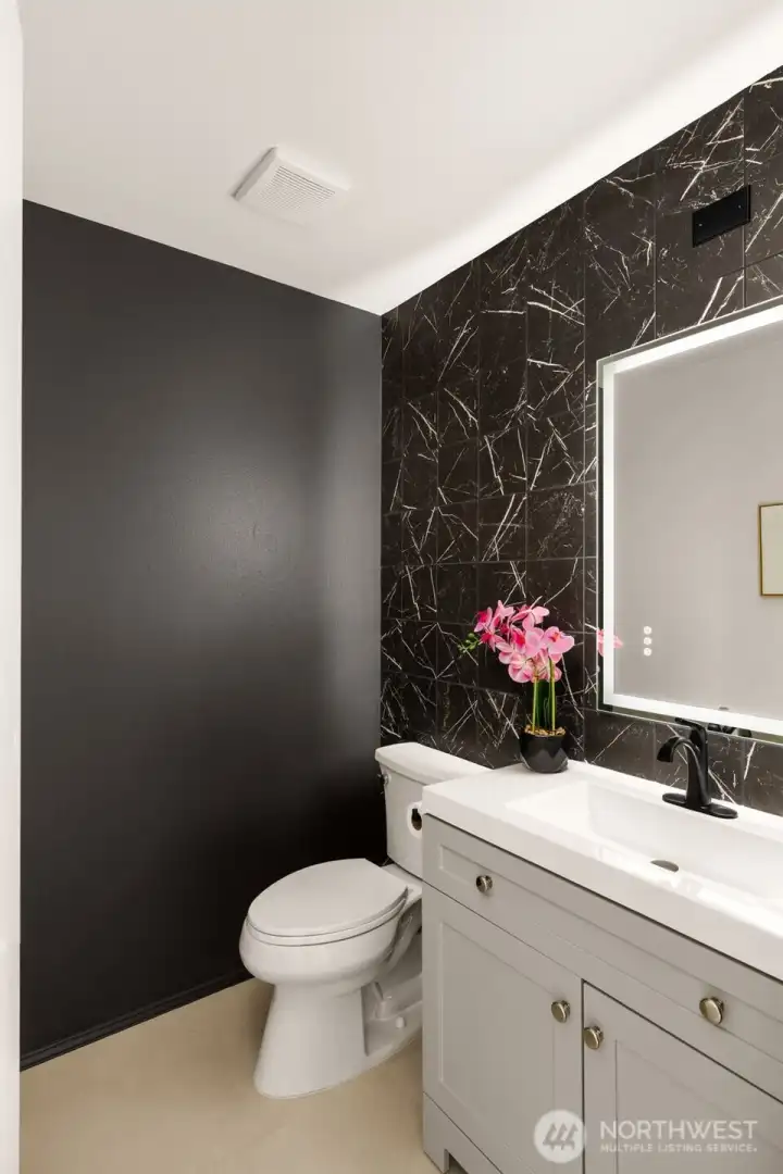 Fully renovated in 2026, this stylish powder room showcases a dramatic floor-to-ceiling tile surround, quartz vanity with soft-close drawers, and a modern LED backlit mirror. Large-format porcelain floor tile completes the sophisticated design.