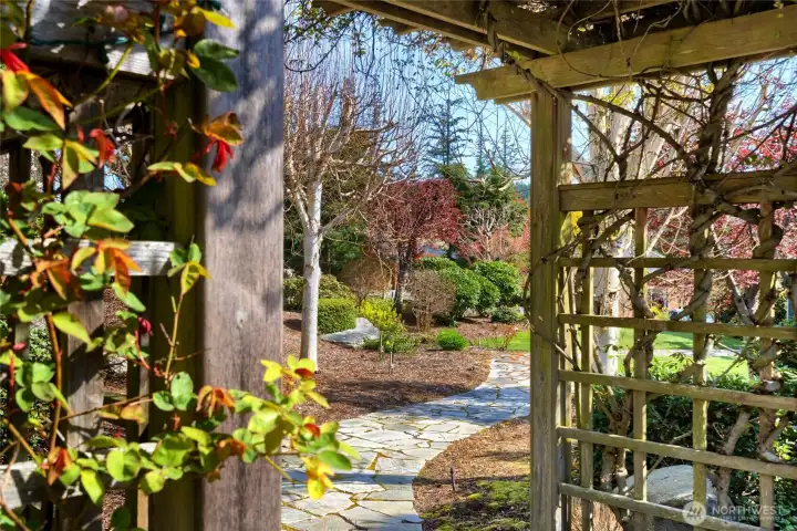 beautiful professionally landscape with flagstone walkway and arbors