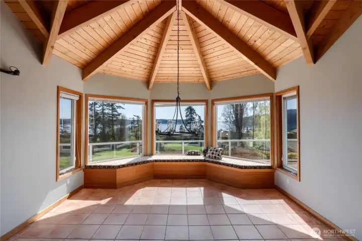 Spacious dining room with sitting area along panoramic windows.