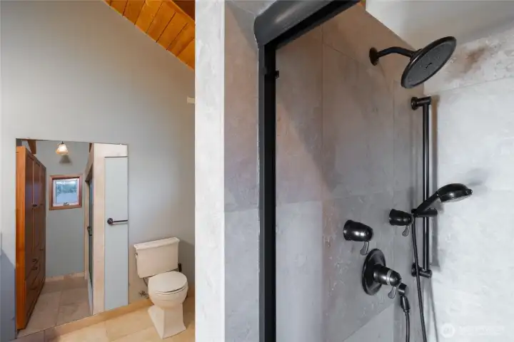 Primary bath - travertine floors and large walk-in shower with custom shower fixtures