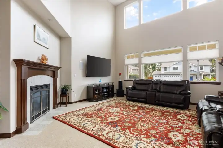 Living room features a dark mahogany wood mantle with tile surround for the natural gas fireplace.