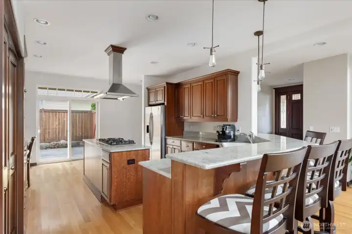 Plenty of dark wood cabinetry and quartz countertops throughout the kitchen.