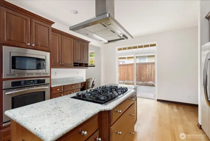 The Kitchen also has an area for another place for a table & chairs with views out through the sliding glass door into the back yard patio.