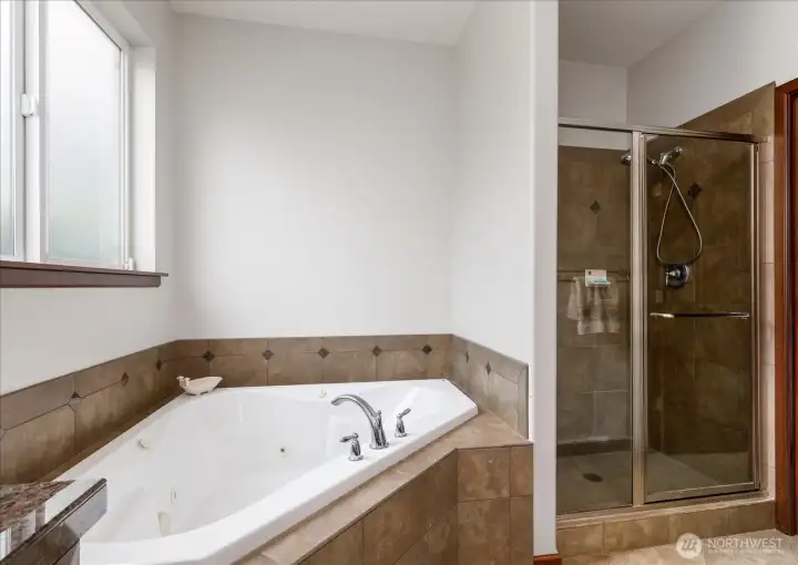 The spacious jetted soaking tub also accompanies a good-size stall shower with a tile surrond.