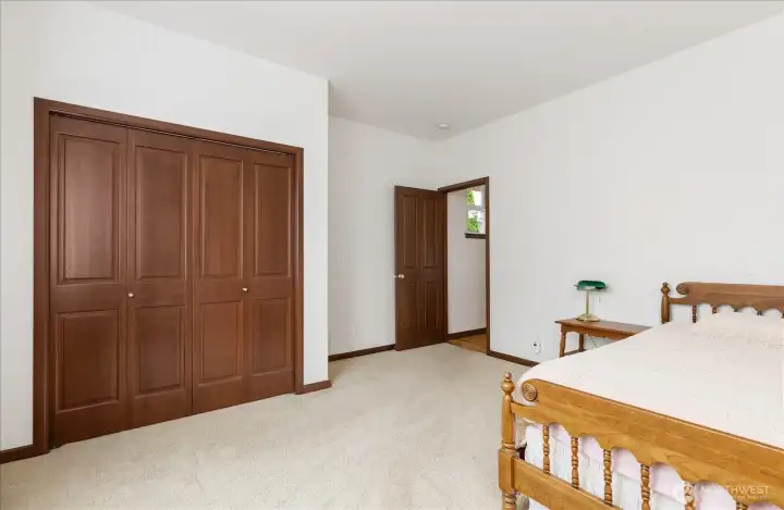 2nd bedroom features a large double door wood closet with plenty of space for clothes & storage.
