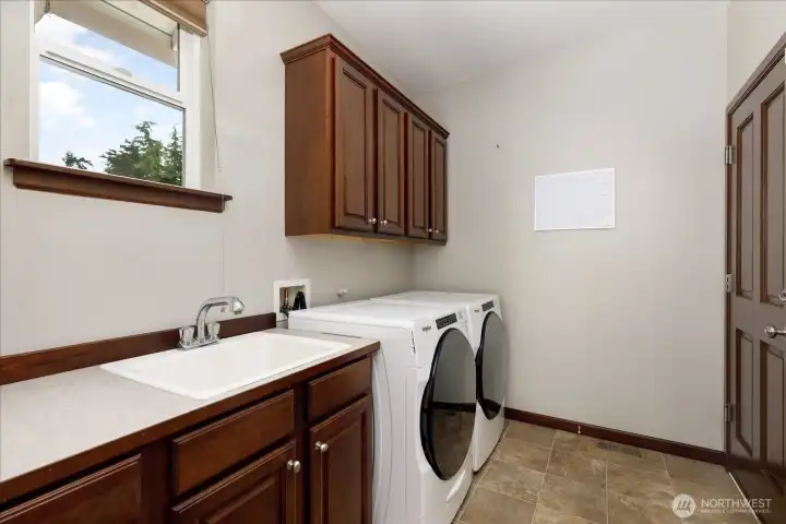 The utility/laundry room is located off of the Kitchen and has a very new washer & dryer, plus a door to the large 2-Car Garage.