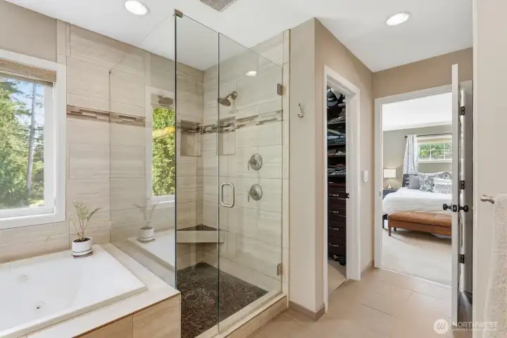 Tiled shower with pebble stone floor and seamless surround and two walk-in closets