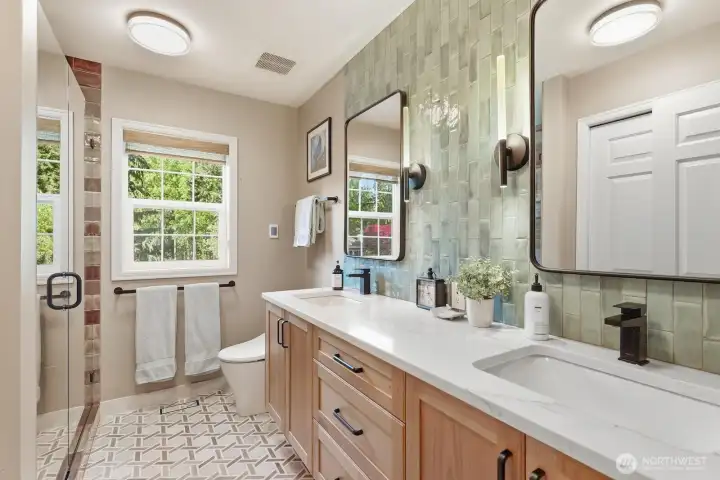 Completely remodeled hall bath with designer tiled shower, quartz vanity, picture mirrors and 12 x 24 tiled floor.