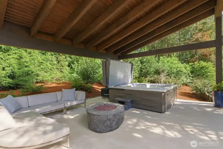 Enjoy a custom covered entertaining area with a gas fire feature and an oversized hot tub.