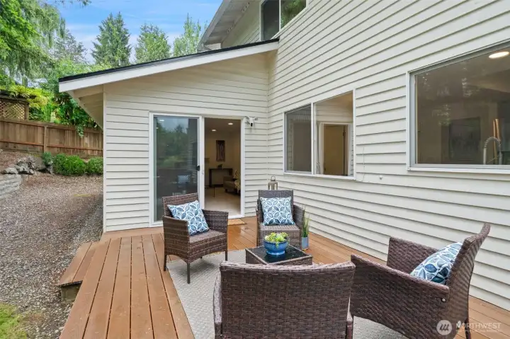Back deck via slider off recreation room for summer evening entertaining beneath mature evergreen trees