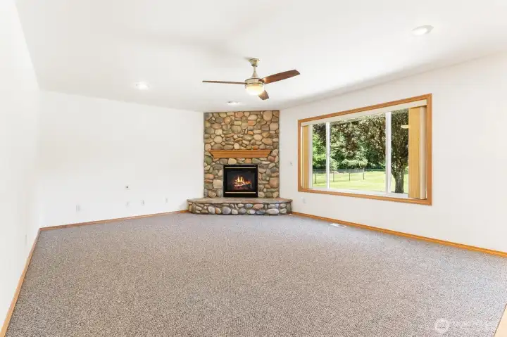 Another view of the cozy living space highlighting the fireplace and lush outdoor views. Another view of the cozy living space highlighting the fireplace and lush outdoor views.