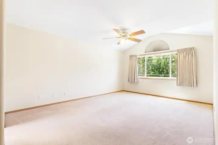 Bright and airy primary suite featuring views of the surrounding greenery. Bright and airy primary suite featuring views of the surrounding greenery.