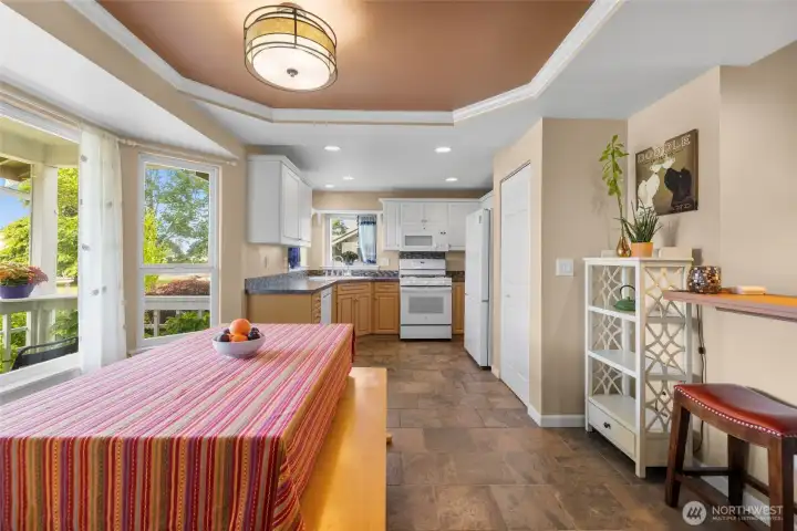Dining area and kitchen with slate floors. Coved ceilings and pantry. Wall of windows for light.