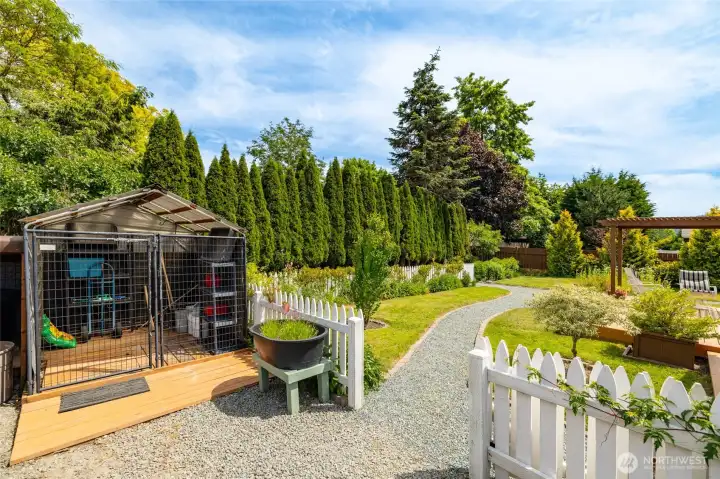 One of the storage sheds. Tall trees in the back behind the fence are on the property line. Fully fenced yard.