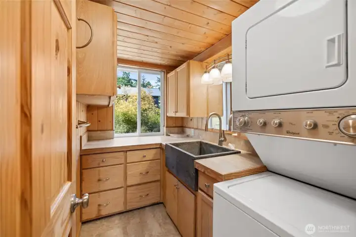 Laundry off entry room has soapstone tub and abundant storage.