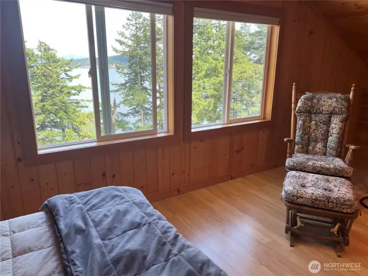 Bedroom has big windows capturing the great view of the water.