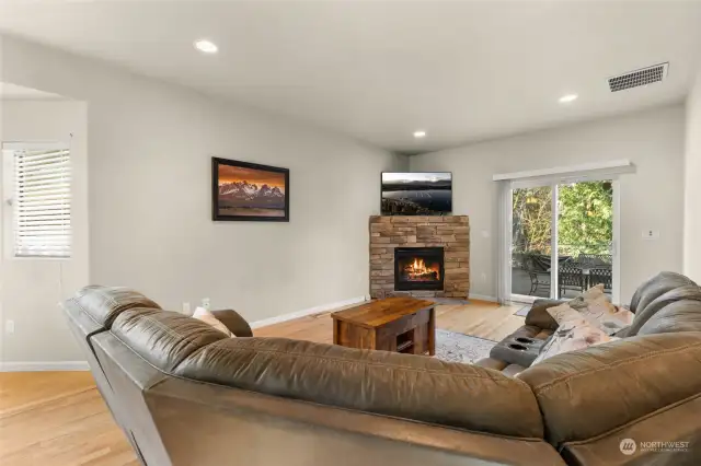 The large living room features an open floor plan connecting to the kitchen, so you’ll never miss a moment. A gas fireplace with a stunning stone facade adds warmth and charm, while a sliding glass door leads to your outdoor entertaining area, complete with a stone patio and fully fenced backyard—perfect for gatherings or relaxing in private.