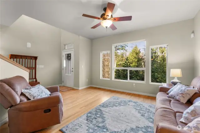 The formal living room is bathed in fantastic natural light, thanks to stunning floor-to-ceiling windows that perfectly frame the serene wooded landscape outside. With nature providing its own masterpiece, there’s no need for additional artwork—this space is a harmonious blend of elegance and tranquility.