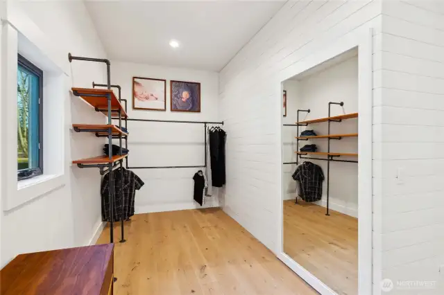 Spaciou primary closet with custom organizers give it that industrial, restoration hardware feel. Behind the mirror is a hidden closet with thumbprint entry!