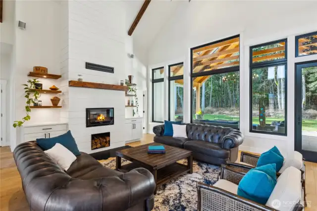 Gorgeous living room with wood burning fireplace, wood box, custom wood mantle and shelving, built in cabinetry, soaring ceilings and Anderson 100 series windows showcasing the lovely, scenic back yard. Allwood Vineyard 9" Engineered Hardwood flooring.