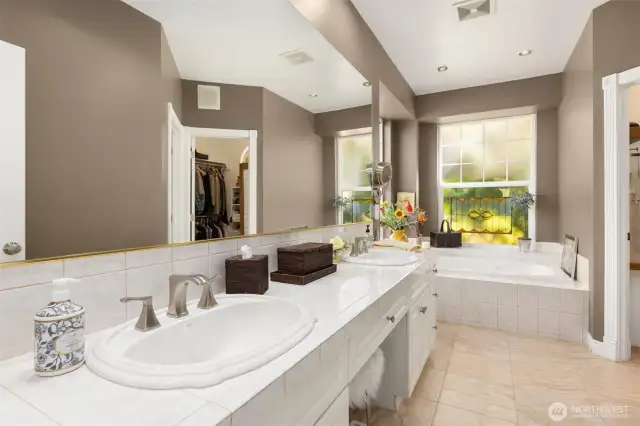 The primary bath features a dual vanity, a relaxing soaking tub, a spacious walk-in closet, and a walk-in shower within a separate water closet