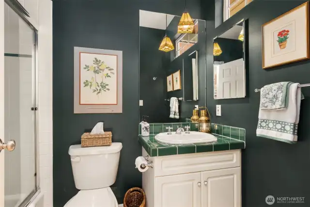 The main floor full guest bath is conveniently located just off the garage entry, making it easily accessible for guests and everyday use. Thoughtfully positioned near the kitchen and dining rooms, it features a practical bath and shower design—perfect for visitors or quick clean-ups after time spent outdoors or entertaining.