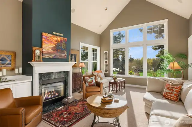 As you step through the foyer, you're instantly captivated by the stunning living room, where a double-sided fireplace and vaulted ceilings create a grand welcome. Expansive windows frame mesmerizing views of Wing Point Golf Club’s lush 17th fairway, tranquil water features, and the ever-entertaining sight of golfers in action—luxury living with a front-row seat to the course.