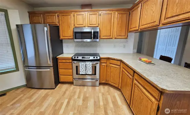 The kitchen's peninsula offers more seating options. Notice the tile backsplash.