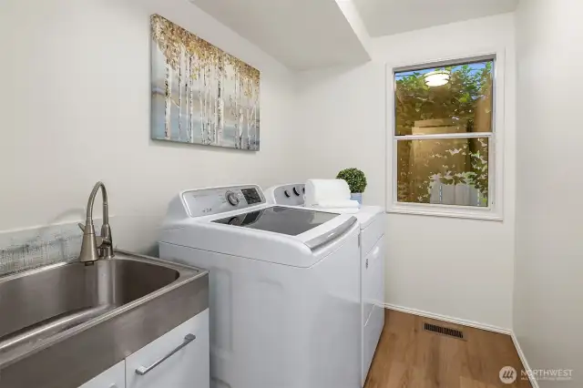 Brand new utility sink, faucet and cabinet, and new LVP floors in the laundry room.