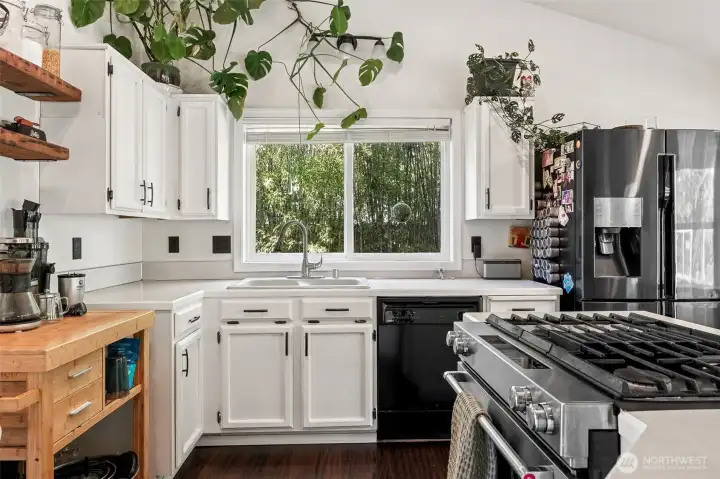 Kitchen features a gas range and lovely views of the yard