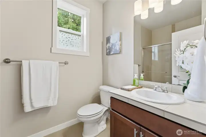 The main-floor 3/4 bath sits just steps from the main floor bedroom, offering an operable window for fresh air and a beautifully clean, bright space