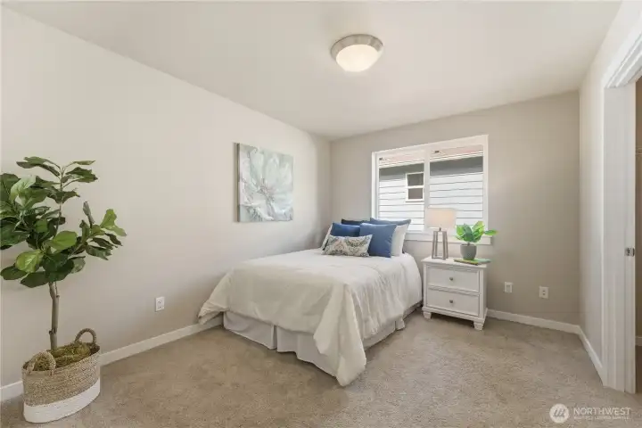 Secondary bedroom staged with a twin bed, featuring a large closet and clean, well-kept carpet