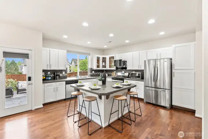 Stunning open concept kitchen designed for both entertaining and everyday living. Featuring a island, abundant prep space, gas stove and sleek upgraded vent hood that lays flat when not in use.